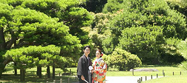 枯山水の飛び石を手を繋いで歩く新郎新婦