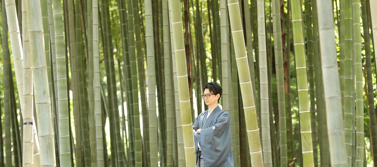 蘆花恒春園の竹林の前で腕を組みポーズをとる新郎